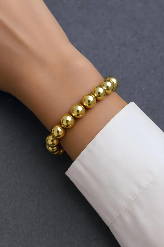 Golden Ballad Bracelet enchants with graceful, golden elegance. Its intricate design and shimmering gilded accents evoke a tender melody of artistry, capturing the allure of timeless charm.